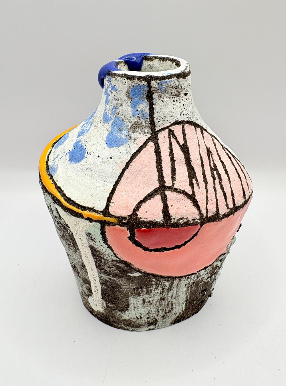 textured bottle vessel with red circle and blue drip